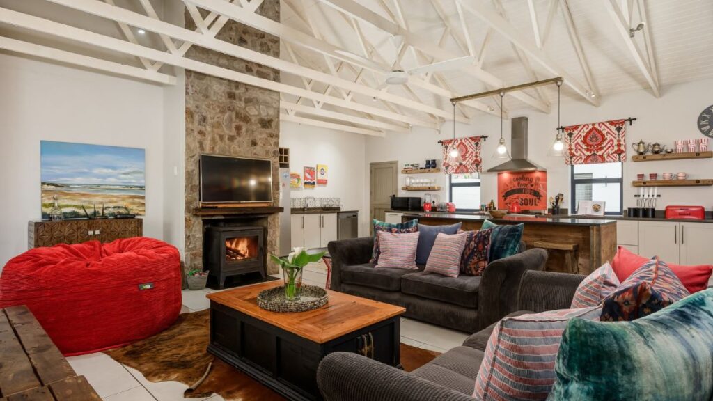 A large open plan living area with red accents and a fireplace