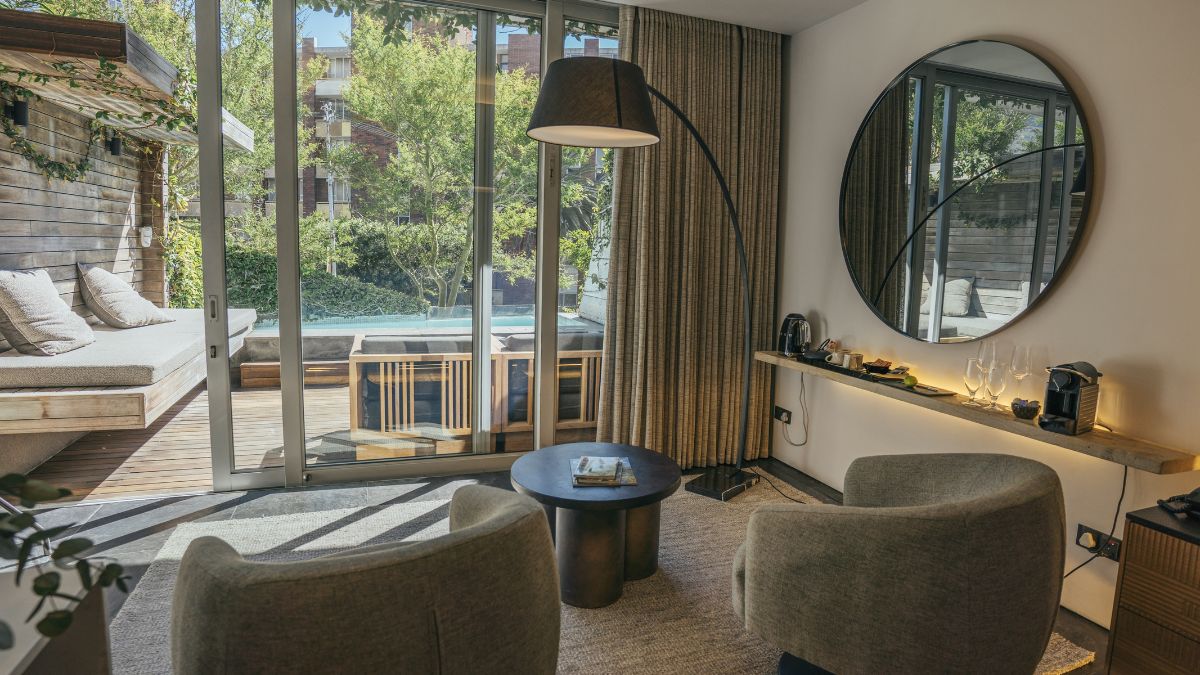 room with plush furnishing and view out to a pool