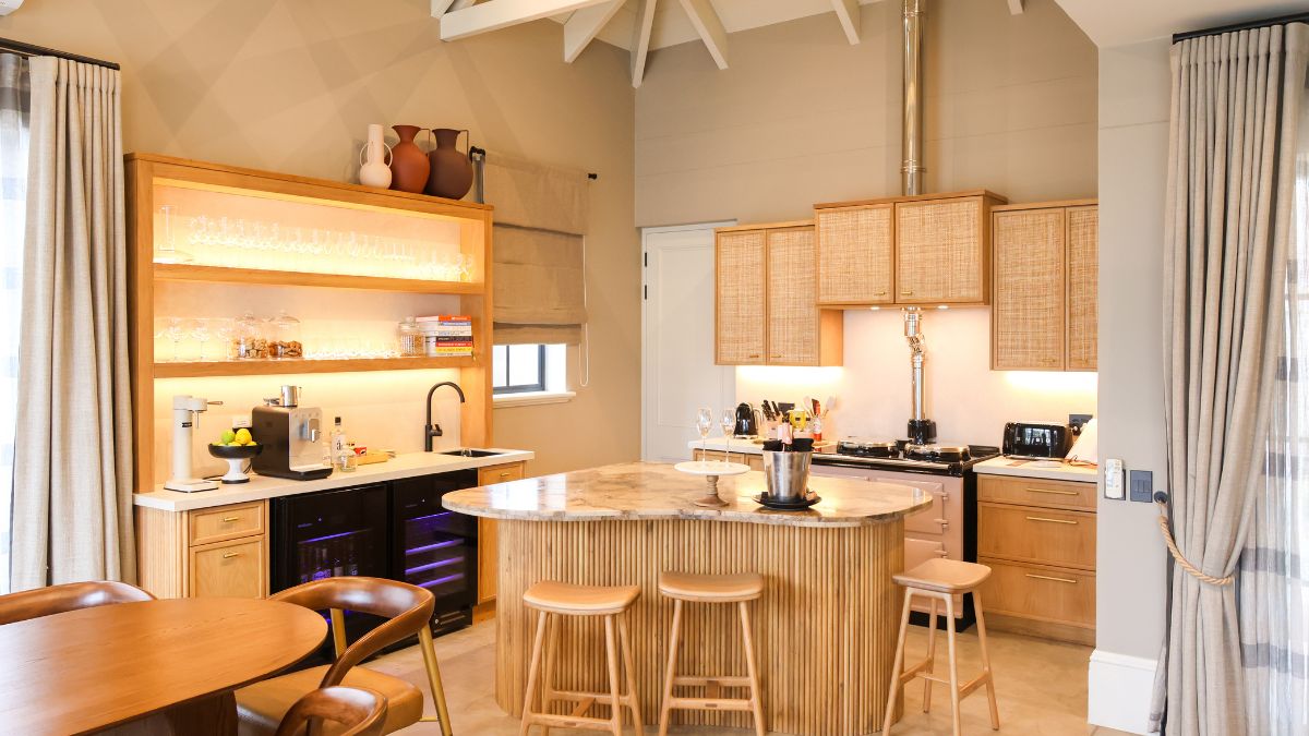 a well appointed kitchen with rattan cupboards and granite top