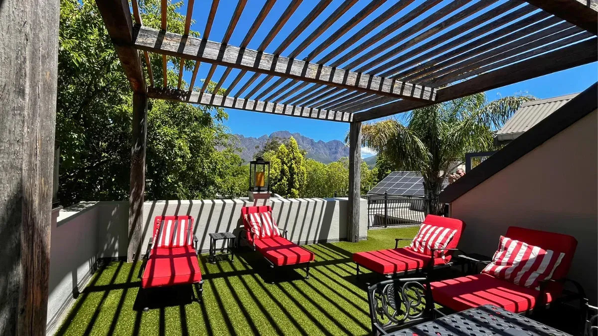 red loungers on a patio with a slatted wood roof