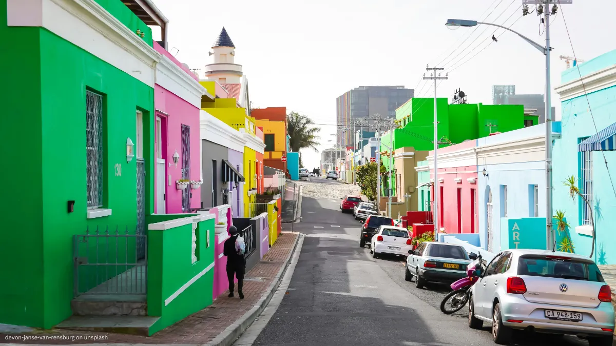 a person walking past colourful homes in Bo Kaap