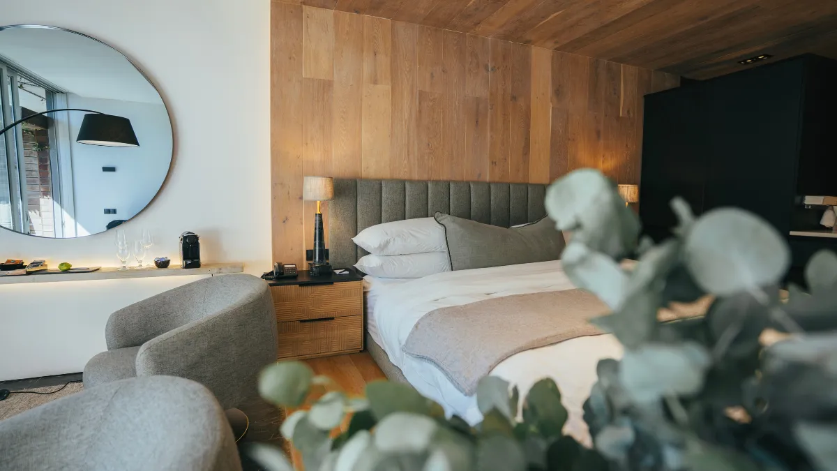 a luxury suite at POD camps bay with wood finishes and white linen