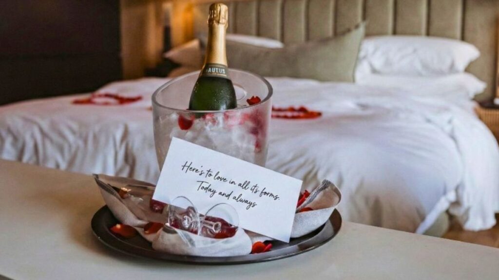 a bottle of sparking wine in a wine cooler with a note of appreciation