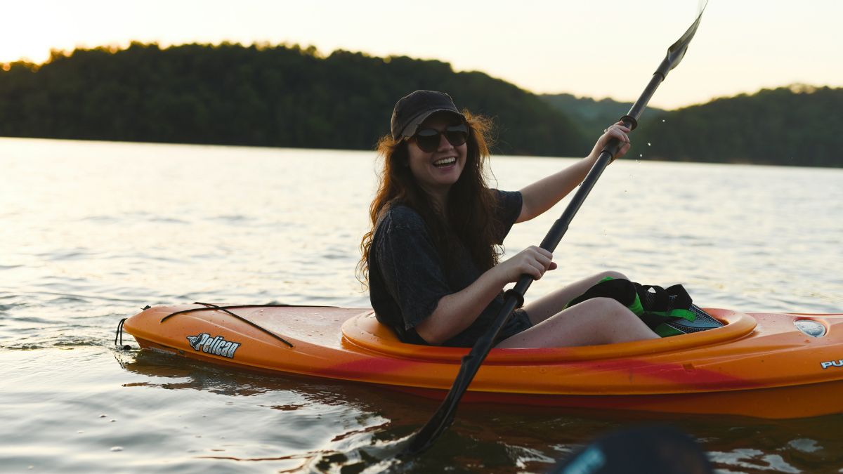 a woman paddling a canoe on a river